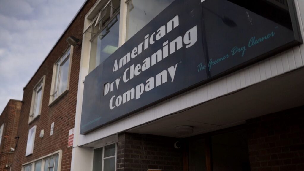 The outside of a building with a sign reading 'American Dry Cleaning Company" on the front