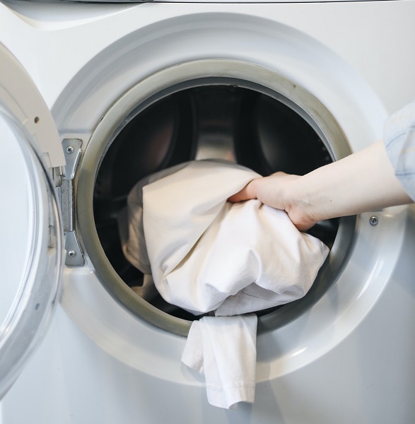 Person putting laundry in a machine