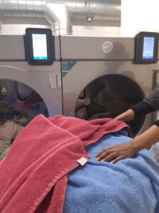 Blue and red towels being held outside of a WASHCONNECT washing machine
